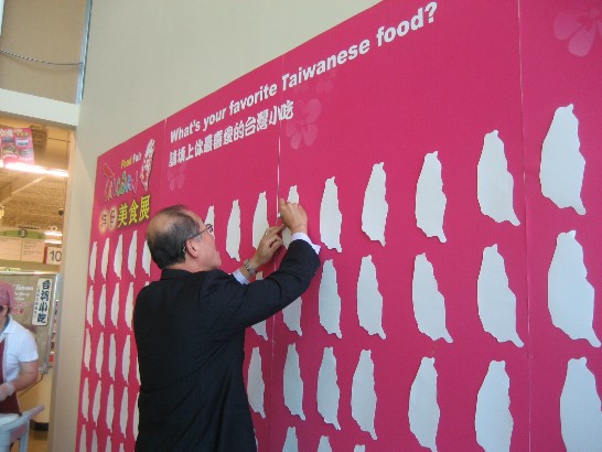 Dr. Lee writes his favourite Taiwan food - oyster pancake on the game board of 2010 Taiwan Festival.