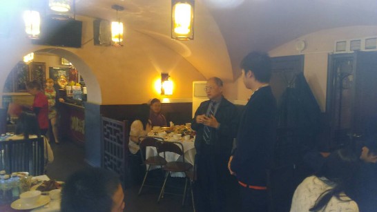 本處王代表建業（左著西裝者）在餐會中與我聖彼得堡留學生閒話家常